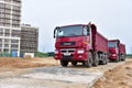 Red dump truck KAMAZ-65801-002-68ÃÂ¢5 8Ãâ¦4 on construction site for transportation of bulk cargo. Trucking industry, freight